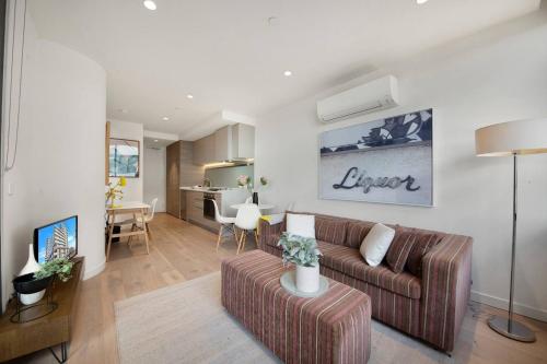 a living room with a couch and a dining room at Cool and Contemporary on the City Edge in Melbourne