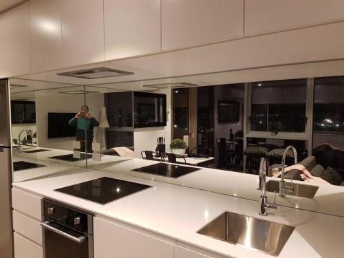 uma pessoa está tirando uma foto de uma cozinha em Luxurious Flemington with Stunning Racecourse View em Melbourne
