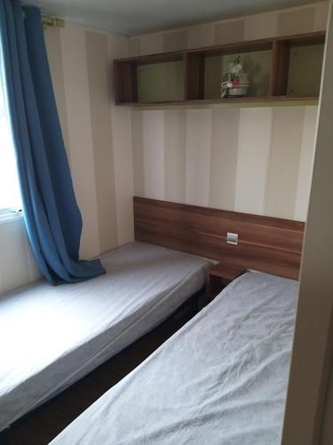 twee bedden in een kleine kamer met een raam bij denise in Saillagouse