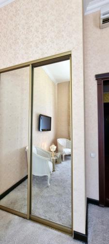 a bathroom with a mirror and a tub in a room at Oreanda Hotel in Odesa