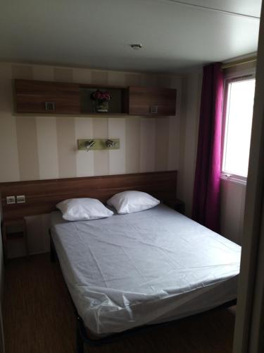 ein Schlafzimmer mit einem Bett mit zwei Kissen und einem Fenster in der Unterkunft denise in Saillagouse