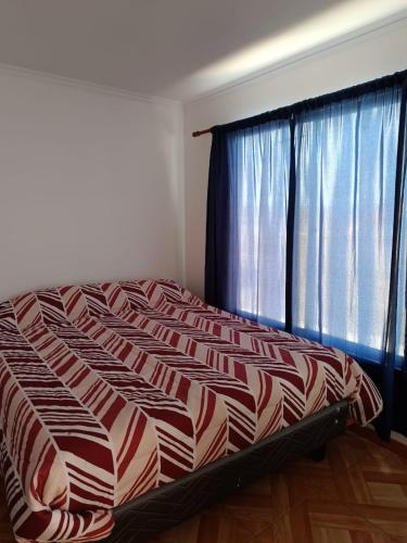 a bed in a room with a large window at Cabañas Tres Islas in Punta de Choros