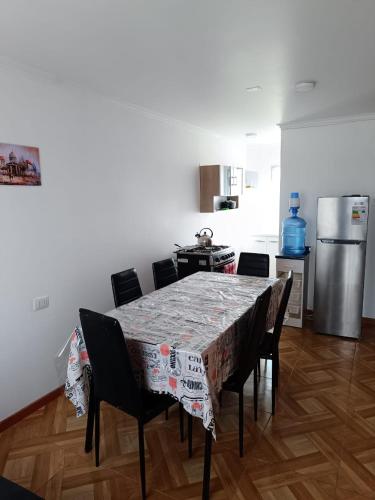 a kitchen with a table with chairs and a refrigerator at Cabañas Tres Islas in Punta de Choros