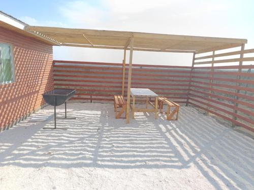 a picnic table and a grill on a patio at Cabañas Tres Islas in Punta de Choros