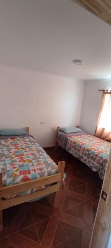 a bedroom with two beds and a window at Cabañas Tres Islas in Punta de Choros