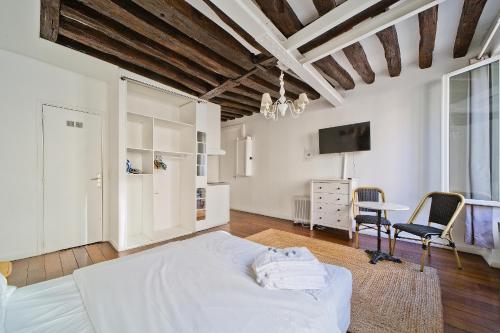 une chambre avec un lit, un bureau et une télévision dans l'établissement Cléry 45, à Paris