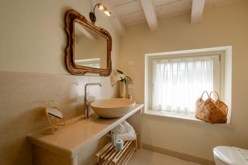 a bathroom with a bowl sink and a mirror at Relais Ca' Morenica in Valeggio sul Mincio