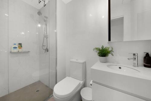 Un baño blanco con inodoro y ducha. en A Cosmopolitan Hub in CBD Centre, en Melbourne