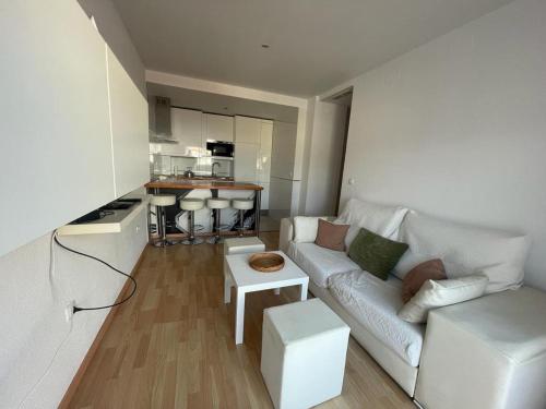 een woonkamer met een witte bank en een keuken bij Apartamento turístico Cristóbal Colón in Huelva