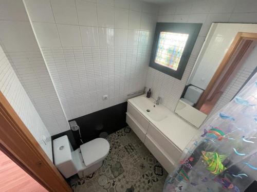 La salle de bains est pourvue de toilettes, d'un lavabo et d'un miroir. dans l'établissement Apartamento turístico Cristóbal Colón, à Huelva