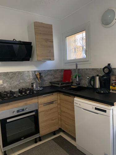 une cuisine avec un évier et une cuisinière four supérieur dans l'établissement Maison entière avec terrasse barbecue et jardin, à Nîmes