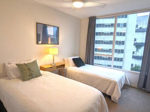 een hotelkamer met 2 bedden en een raam bij Treetop Tranquillity on Queen in Melbourne