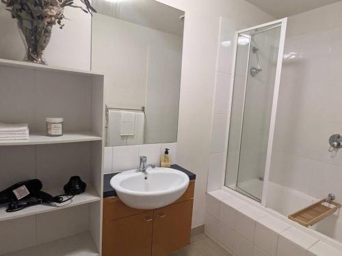 a white bathroom with a sink and a shower at Treetop Tranquillity on Queen in Melbourne