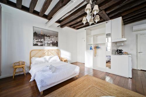 Cet appartement comprend une chambre avec un lit blanc et une cuisine. dans l'établissement Cléry 45, à Paris