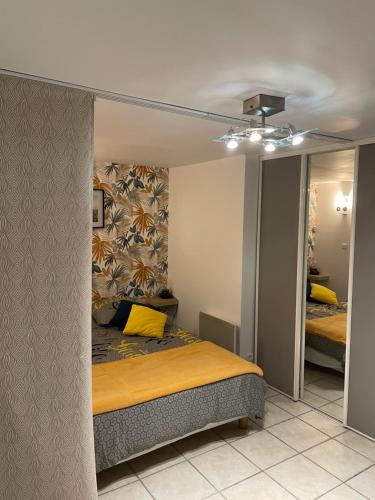 a bedroom with a bed with a yellow pillow at STUDIO 3 Mn de la PLAGE Terrasse Vélos Proche de la ville fortifiée in Saint Malo