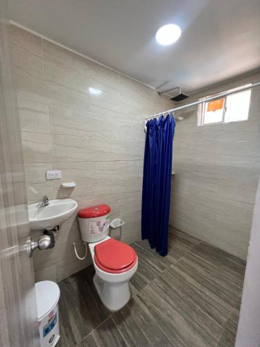 een badkamer met een rood toilet en een wastafel bij Quinta la moro in Melgar