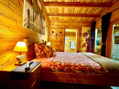 a bedroom with a bed in a log cabin at Chalet Chevreuil avec piscine privée in Lucéram