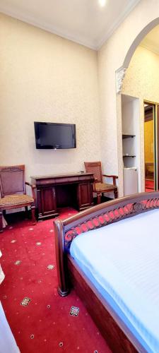 a hotel room with a bed and a flat screen tv at Oreanda Hotel in Odesa