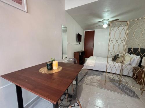 Cette chambre dispose d'une table en bois et d'un lit. dans l'établissement Sophistication and Rest , Room, Bathroom, Kitchen, à Xalapa