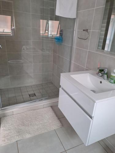 a bathroom with a white sink and a shower at THE BLYDE Holiday Apartments in Pretoria