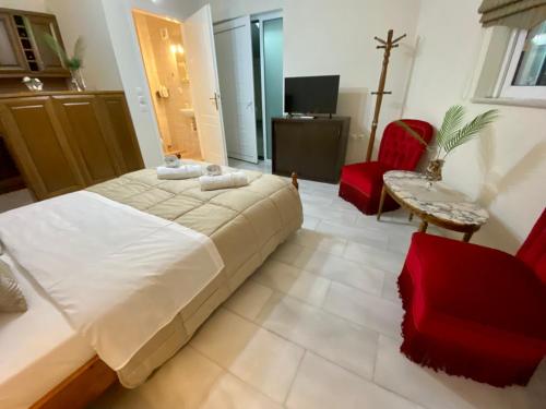 スパタにあるNikos Apartmentのベッドルーム1室(大型ベッド1台、赤い椅子付)