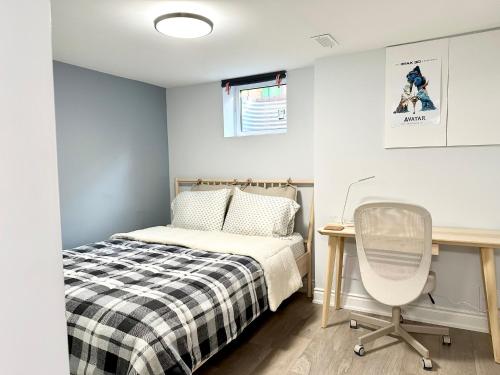 1 dormitorio con cama, escritorio y silla en Cozy & Comfortable basement apartment, en Mississauga