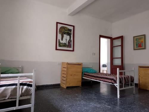 聖薩爾瓦多德胡胡伊的住宿－HOSTEL LA ESPAÑOLA，一间卧室配有两张床、一个梳妆台和镜子