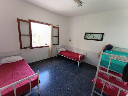 聖薩爾瓦多德胡胡伊的住宿－HOSTEL LA ESPAÑOLA，客房设有两张双层床和一扇窗户。