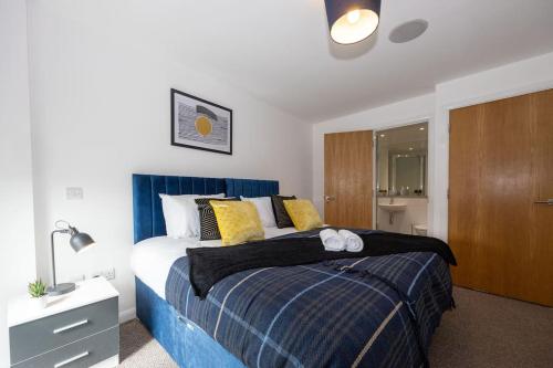 a bedroom with a large bed with a blue blanket at Stylish Northern Quarter 2Bed, Free Parking, WI-FI, Sleeps 4, Central Location, Long term Disc in Manchester