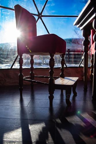 a chair sitting in front of a window with the sun at BUNNY GLAMP in Korbielów