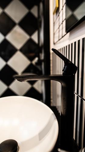 a bathroom sink with a black and white checkered floor at BUNNY GLAMP in Korbielów