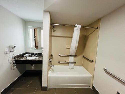 a bathroom with a bath tub and a sink at Clarion Pointe Lakeland I-4 in Lakeland