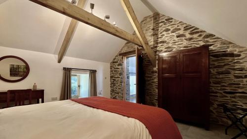 a bedroom with a bed and a stone wall at Charming Countryside Barn in Pencader