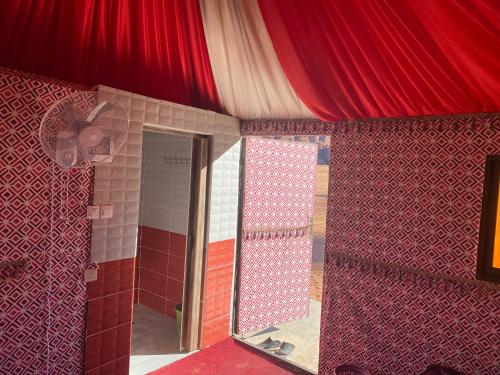 um quarto com um tecto vermelho e um espelho em Wadi Rum Sights Camp em Wadi Rum