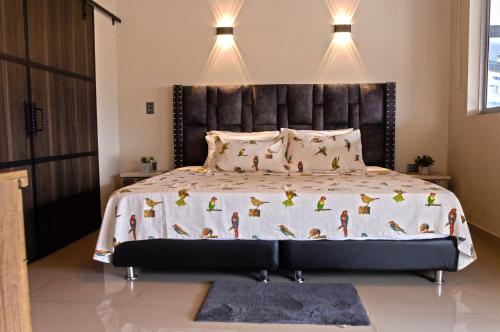 a bedroom with a large bed with a black headboard at Lindo apartamento con terraza en Bello Ant in Bello