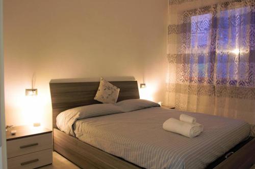 een slaapkamer met een bed met twee handdoeken erop bij Appartamento Trilocale “Il Regio” in Montescudaio