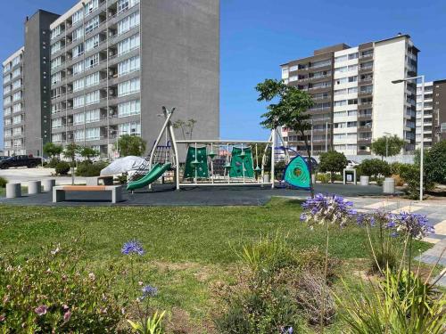 a playground in a park with buildings in the background at Condominio Río Elqui in La Serena
