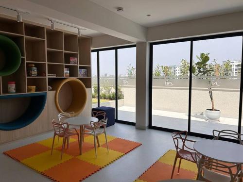 Habitación con 2 mesas, sillas y ventanas en Bellísimo departamento de estreno en Barranco en Lima
