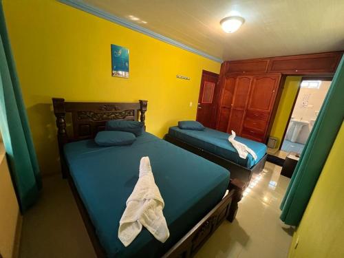 1 dormitorio con 2 camas y toallas. en Posada Faych House, en San Andrés