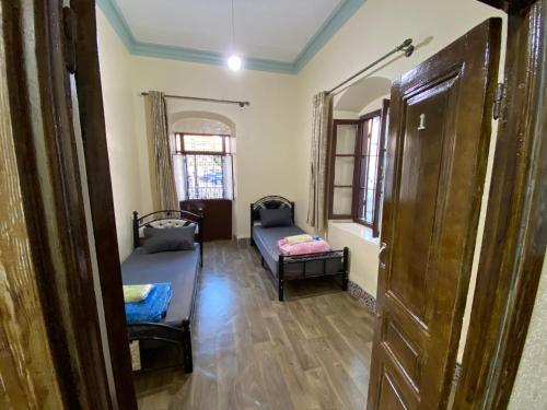 um quarto com duas camas e uma porta em Private room in the kasbah em Tânger