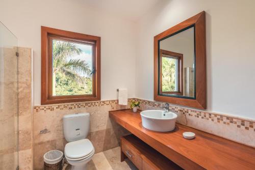 a bathroom with a sink and a toilet and a mirror at Luxe retreat at Puerto Bahia Bkfst included in Santa Bárbara de Samaná