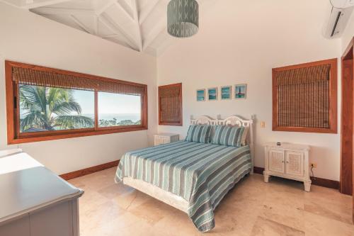 a bedroom with a bed and a large window at Luxe retreat at Puerto Bahia Bkfst included in Santa Bárbara de Samaná