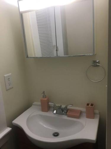 スケネクタディにある2 bedroom suiteのバスルーム(大きな鏡と鏡付きの洗面台付)