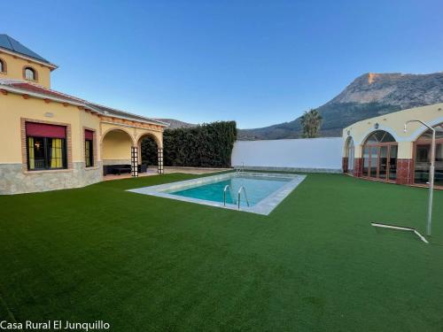 Un patio con piscina y una casa. en Casa Rural El Junquillo, en Cuevas de San Marcos