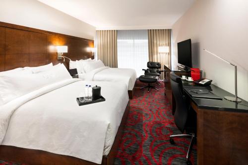 een hotelkamer met 2 bedden en een bureau bij OTL Gouverneur Sherbrooke in Sherbrooke