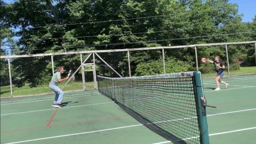 two people playing tennis on a tennis court at Finlays Cove on the Lake in Colchester