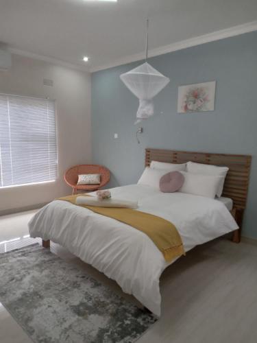 a bedroom with a large bed and a chair at Chaya accommodation B&B and self catering in Mzuzu