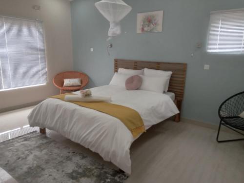 a bedroom with a bed with white sheets and pillows at Chaya accommodation B&B and self catering in Mzuzu