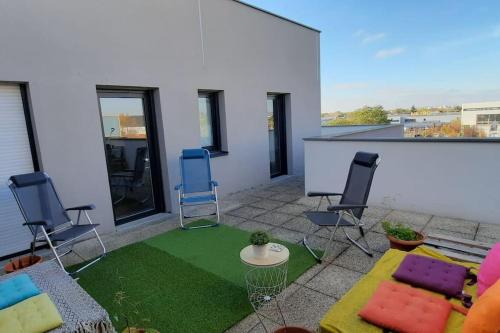 a patio with chairs and a green rug at Magnifique appartement avec terrasse et parking, 8 Personnes in Nanterre
