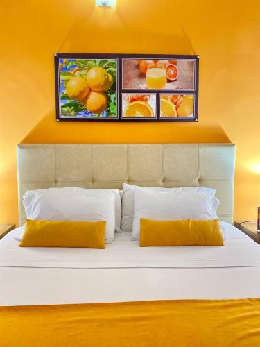 a bed with two pillows and a painting on the wall at Hotel Aromax del Campestre in Medellín